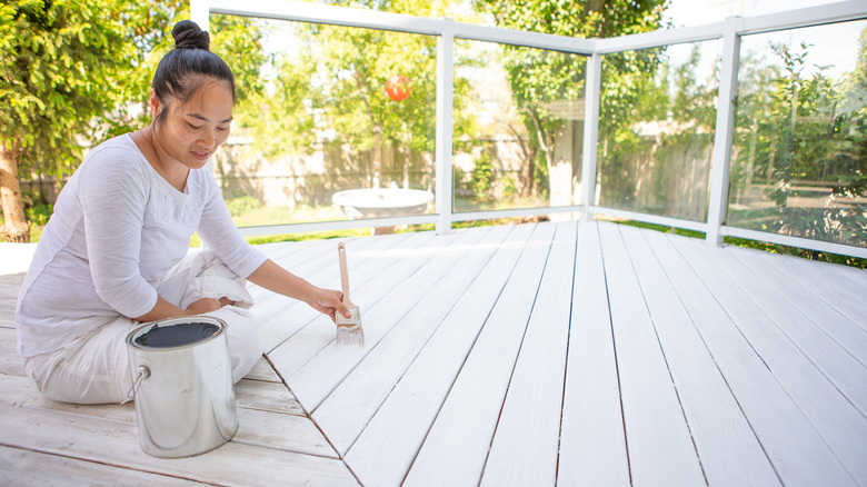 woman painting a deck