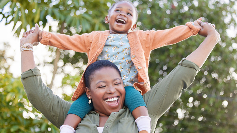 mother with daughter on shoulders