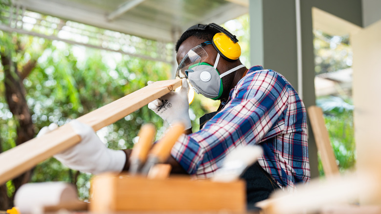carpenter looking at a piece of wood during woodworking