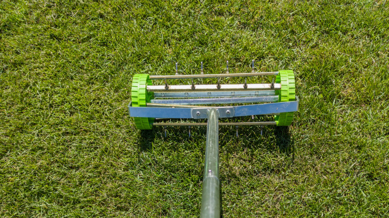 A lawn aeration tool on green grass.