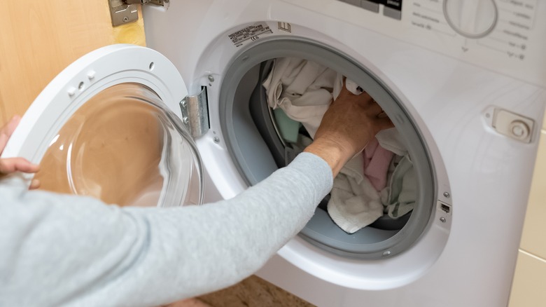 Woman loading washing machine