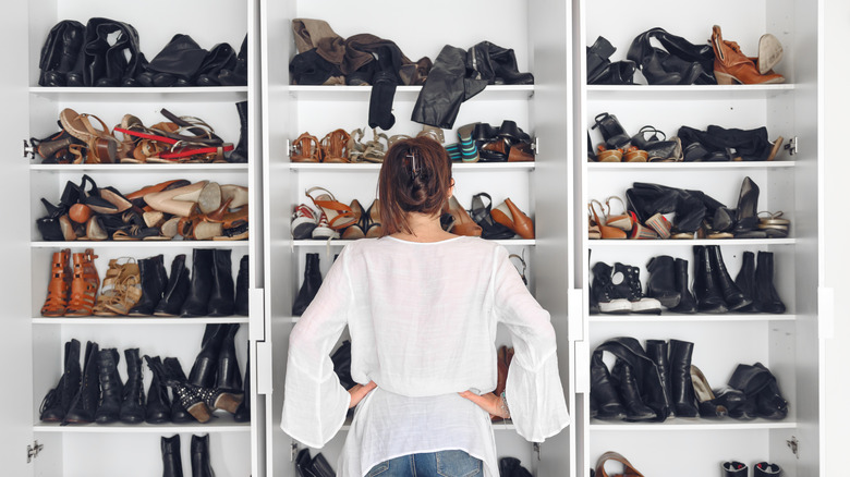 Woman looking at messy shoe closet