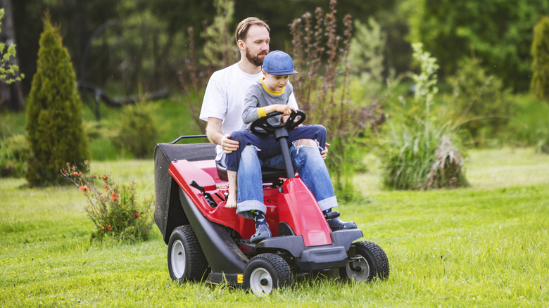 Father and son tackling the lawn on a compact riding mower with a modest deck size
