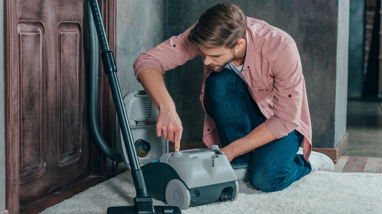 Man inspecting a vacuum cleaner