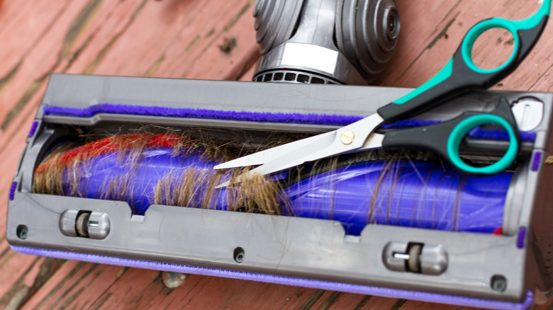 Scissors cutting hair from vacuum roller