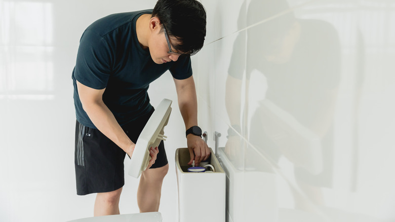 Man working on a toilet tank