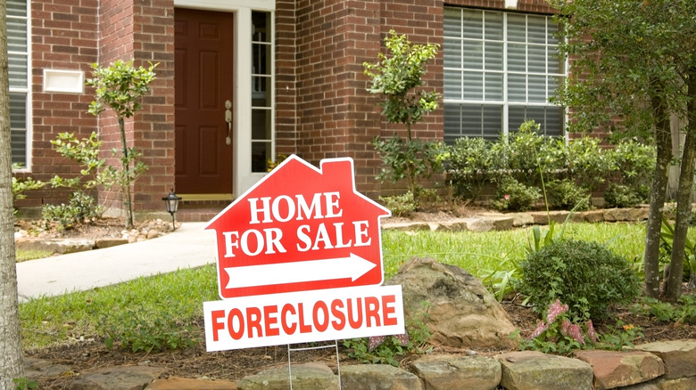 Home with foreclosure sign in yard