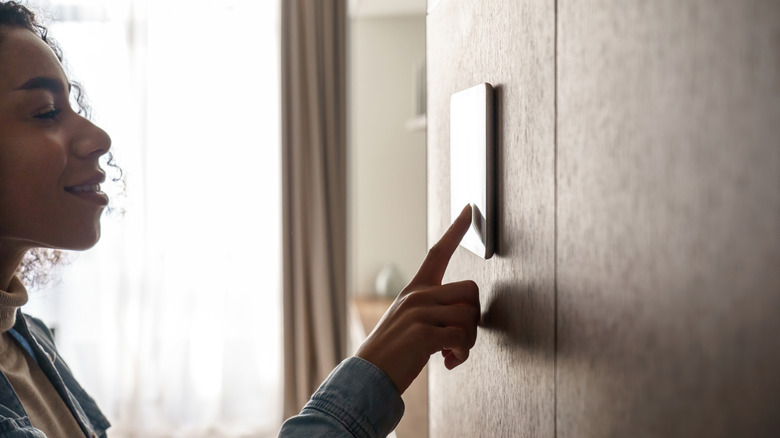 Woman setting thermostat