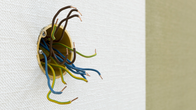 Loose wires exposed from a wall outlet
