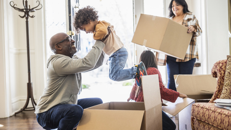A happy family unpacks boxes in their new home.