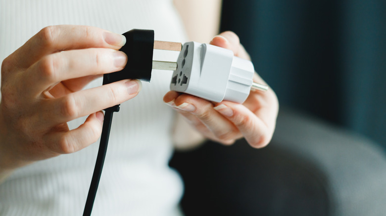 Person putting plug in adapter