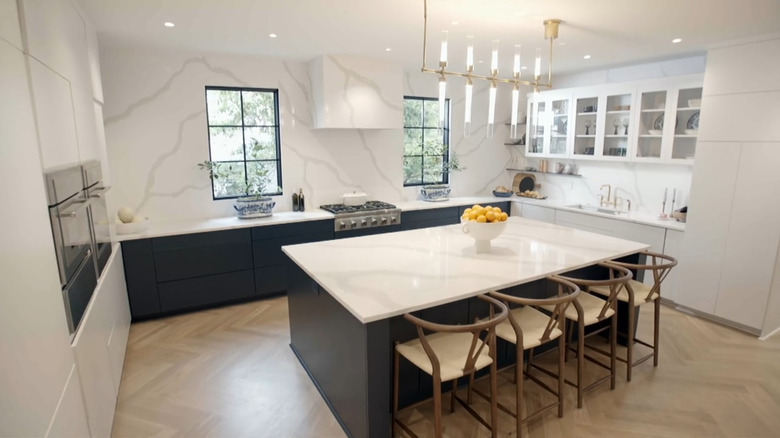 A kitchen with white quartz and black cabinets.
