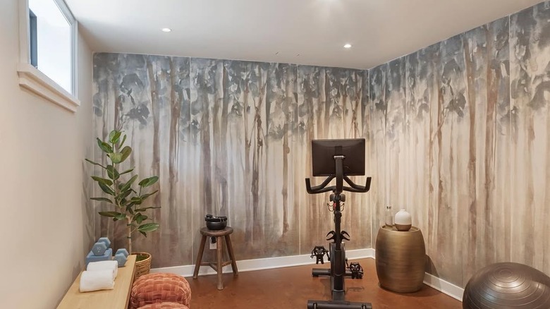 A home gym with tree wallpaper.