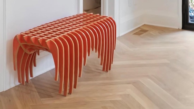 An abstract orange bench in an entryway.