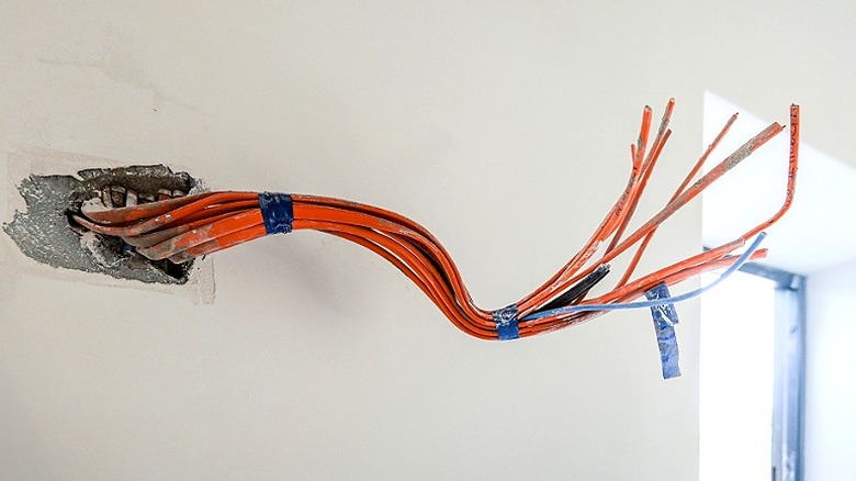 A bundle of orange wiring sticking out of a wall