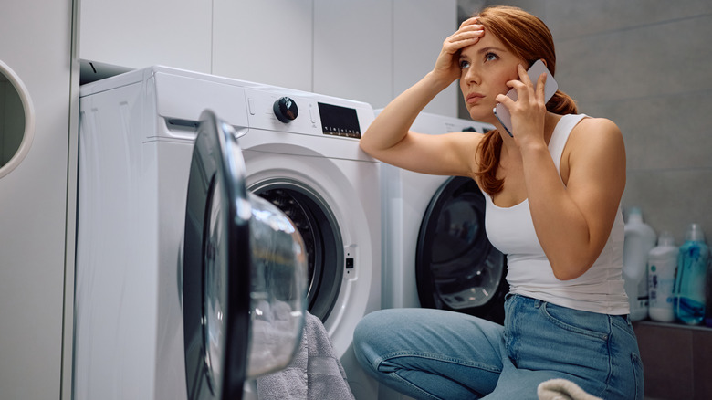 woman next to washing machine on phone