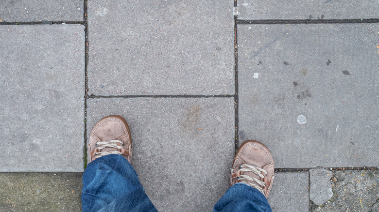 person's feet on concrete sidewalk