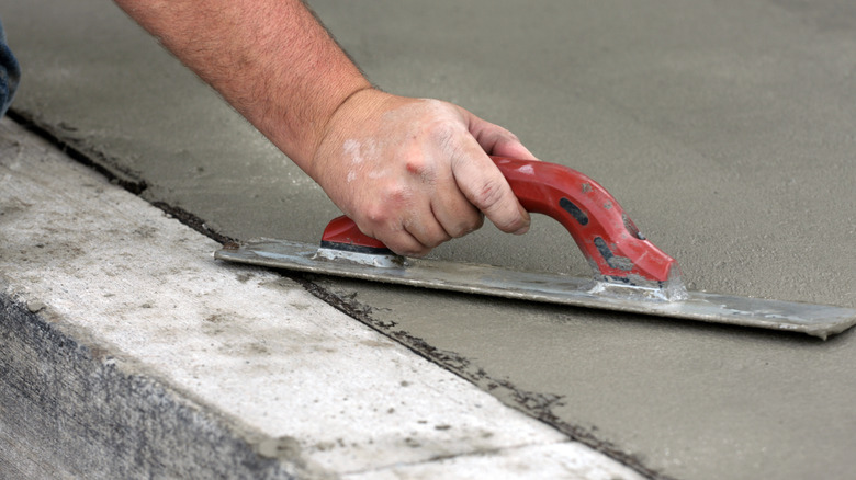 person trowels concrete