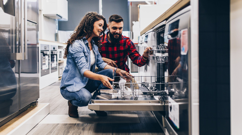 couple looking at dishwasher in store