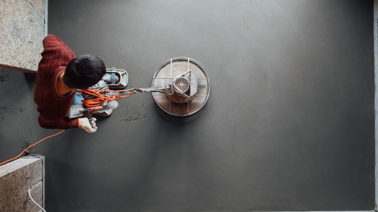 man grinding concrete sub-flooring