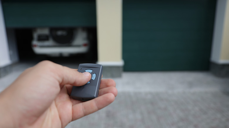 Person pressing a button on a garage door opener