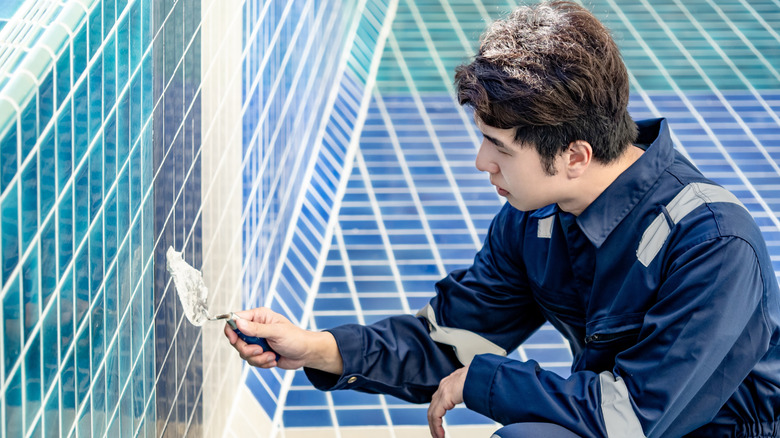construction worker grouting pool tiles