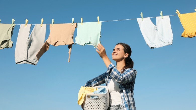 Smiling woman and hang-drying laundry