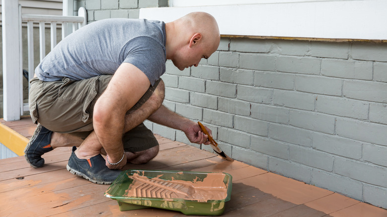 Man painting porch floor