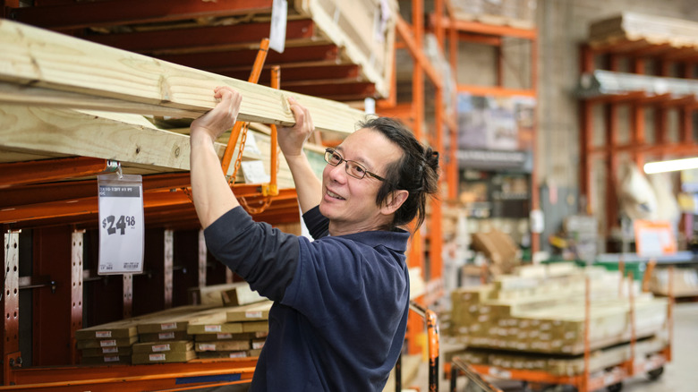 Man buying wood planks at a home improvement store