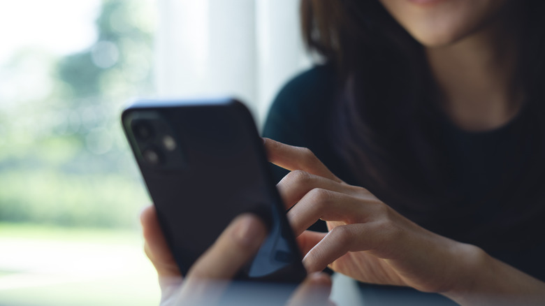 person looking up info on smartphone