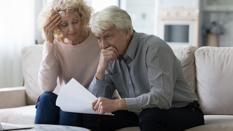 Elderly couple appearing stressed