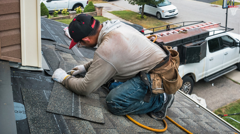 Man working to seal the roof of a home