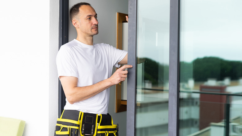 person inspecting sliding patio doors