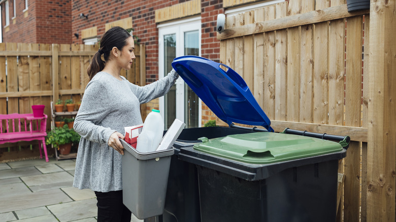 Woman placing trash in a garbage can