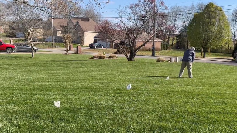 Person marking underground lines with small flags