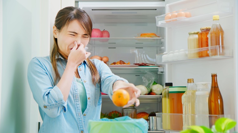 Woman removing rotten fridge food