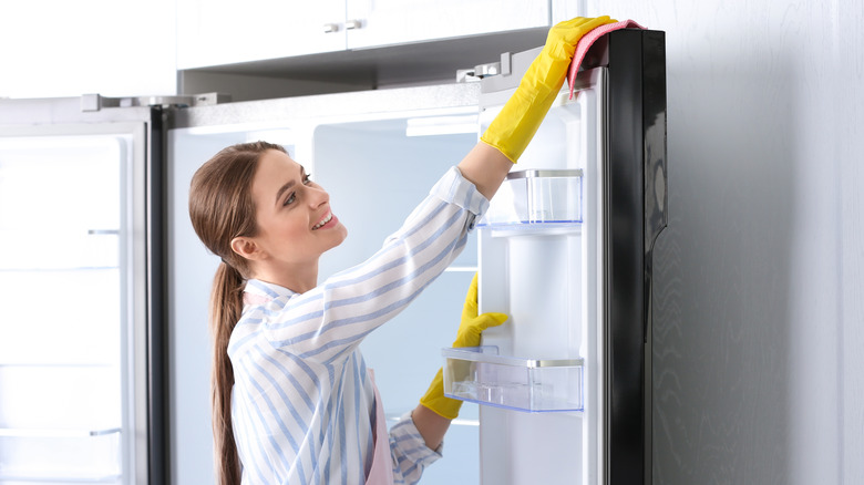Woman cleaning fridge door seals