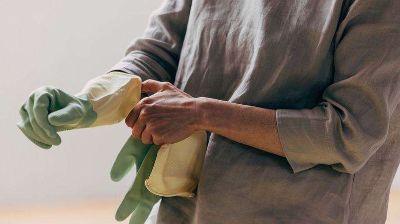 Person putting on rubber gloves for cleaning.
