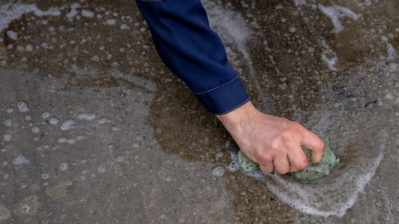 person scrubbing garage floor