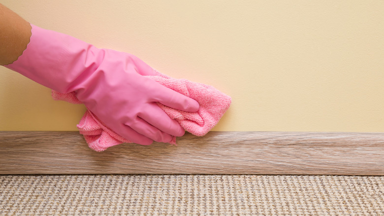 gloved hand cleaning wall