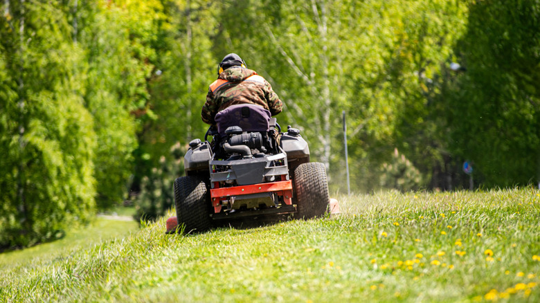 A riding mower being used on slightly uneven terrain