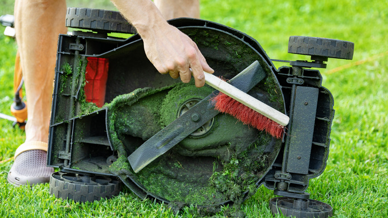 Cleaning old grass clippings from a mower