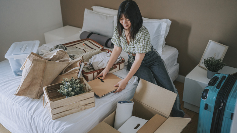 Young woman decluttering bedroom