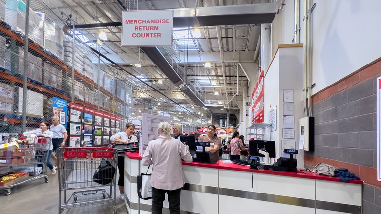 Merchandise return counter in a Costco store, two customers in line
