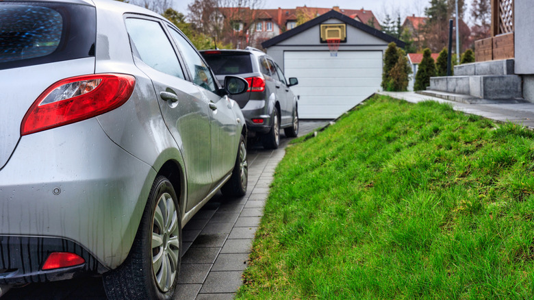 One car blocks in an SUV in a residential driveway