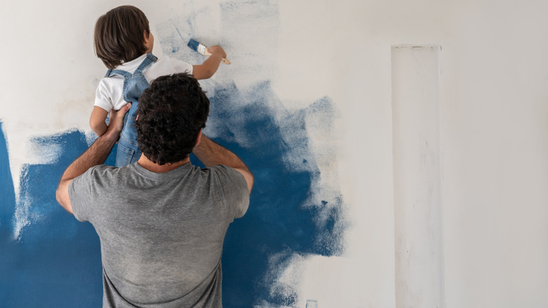 father and son painting wall