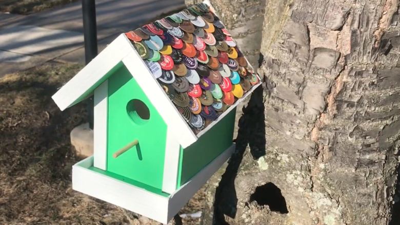 A birdhouse decorated with bottlecaps