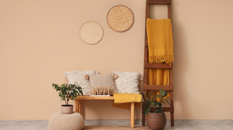 A blanket ladder with yellow blanket next to a table