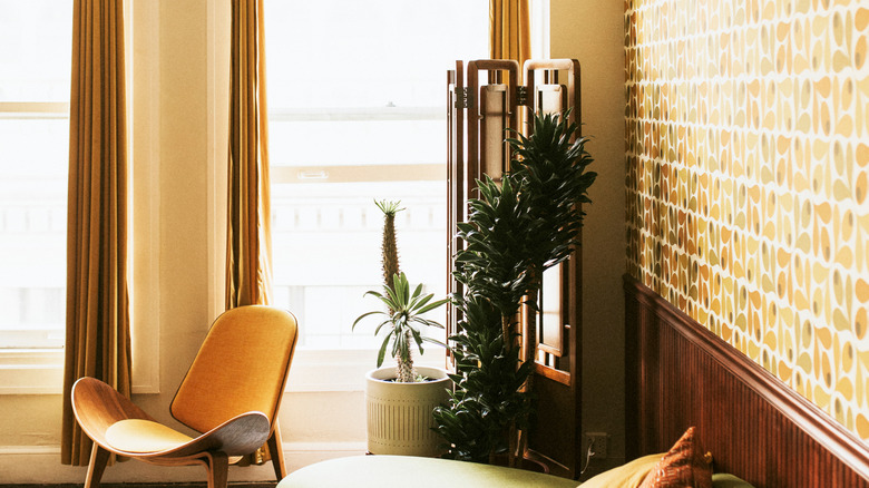 A mid century living room with bold wallpaper.