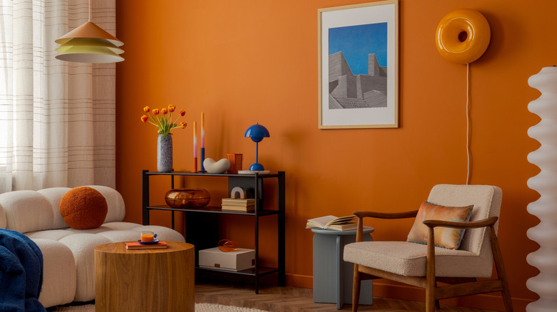 A retro living room with orange walls.